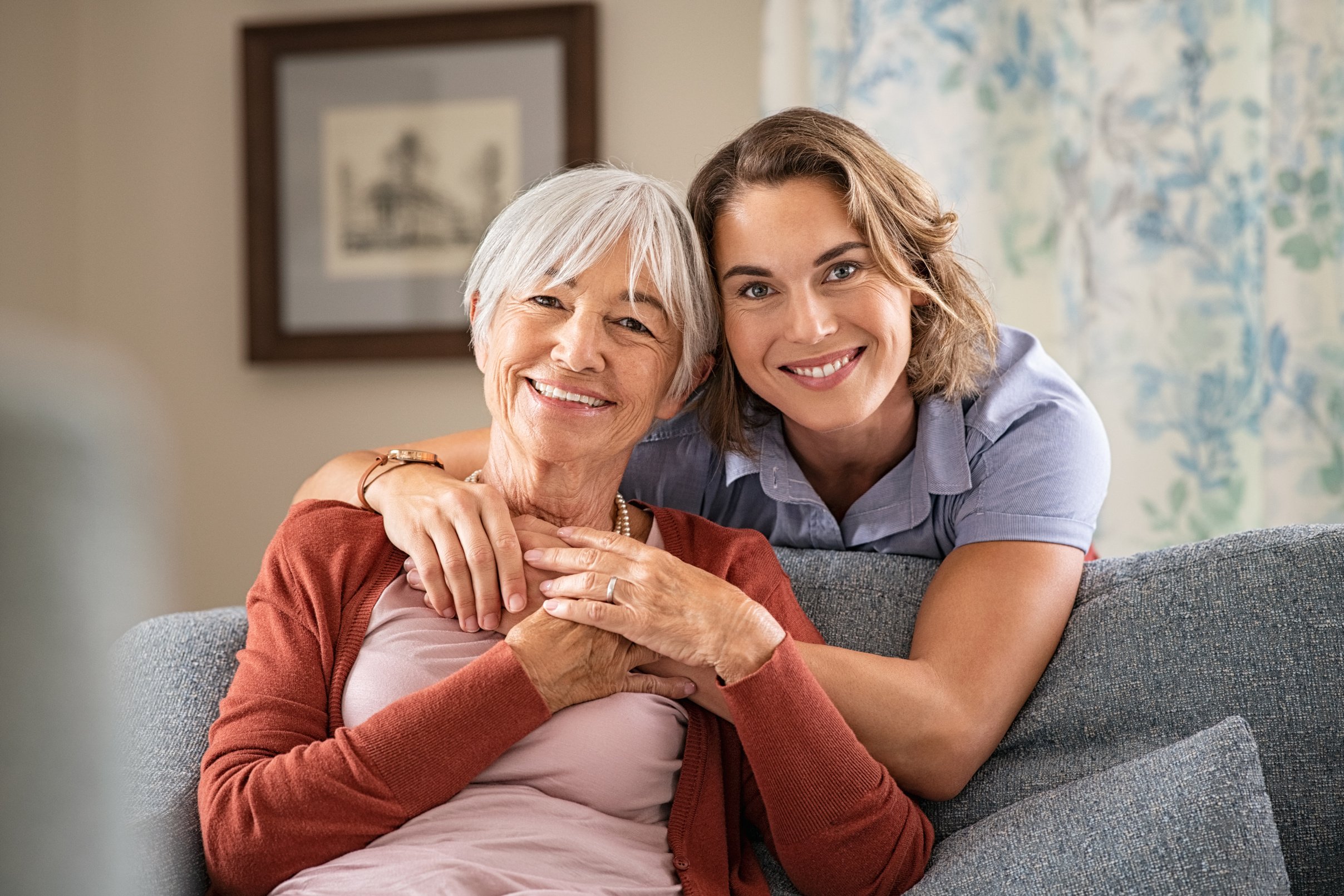 Happy Adult Daughter Embracing Elderly Woman